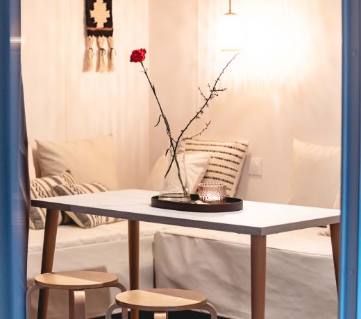 Interno accogliente con tavolo, sgabelli e decorazioni minimaliste.
