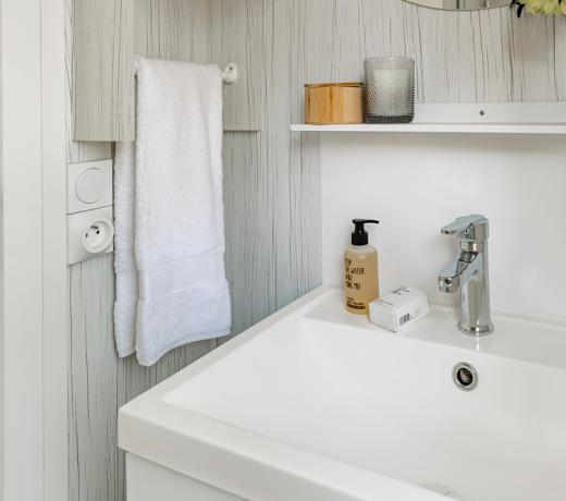 Bagno moderno con lavandino, asciugamano e decorazioni semplici.