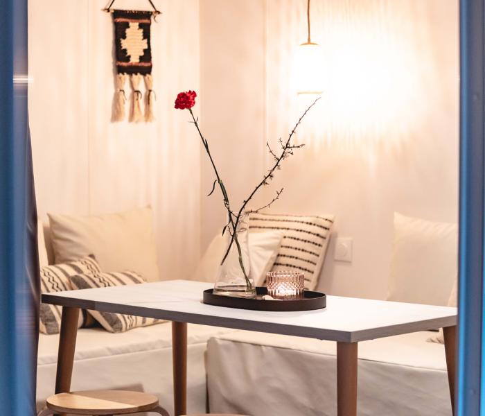 Interno accogliente con tavolo, sgabelli e decorazioni minimaliste.