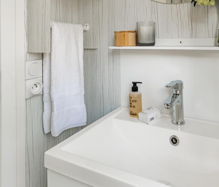 Bagno moderno con lavandino, asciugamano e decorazioni semplici.